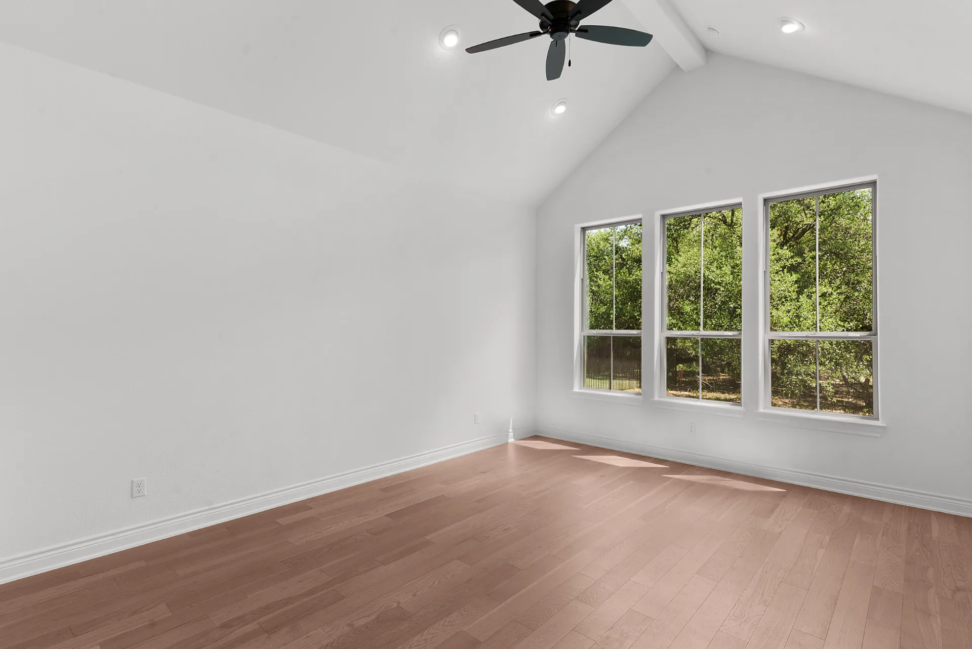 Bedroom with vaulted ceiling and windows