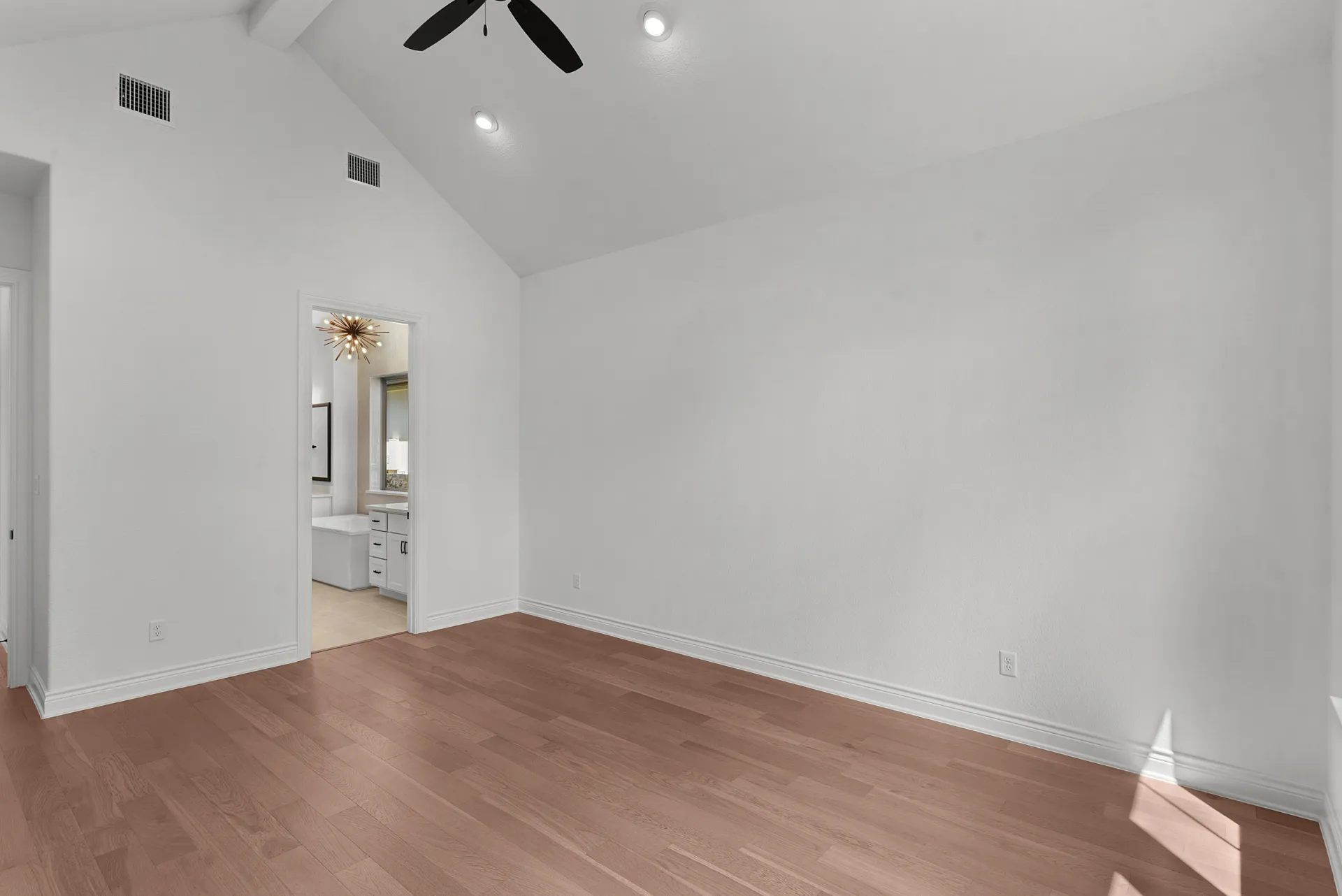 Primary bedroom with vaulted ceiling
